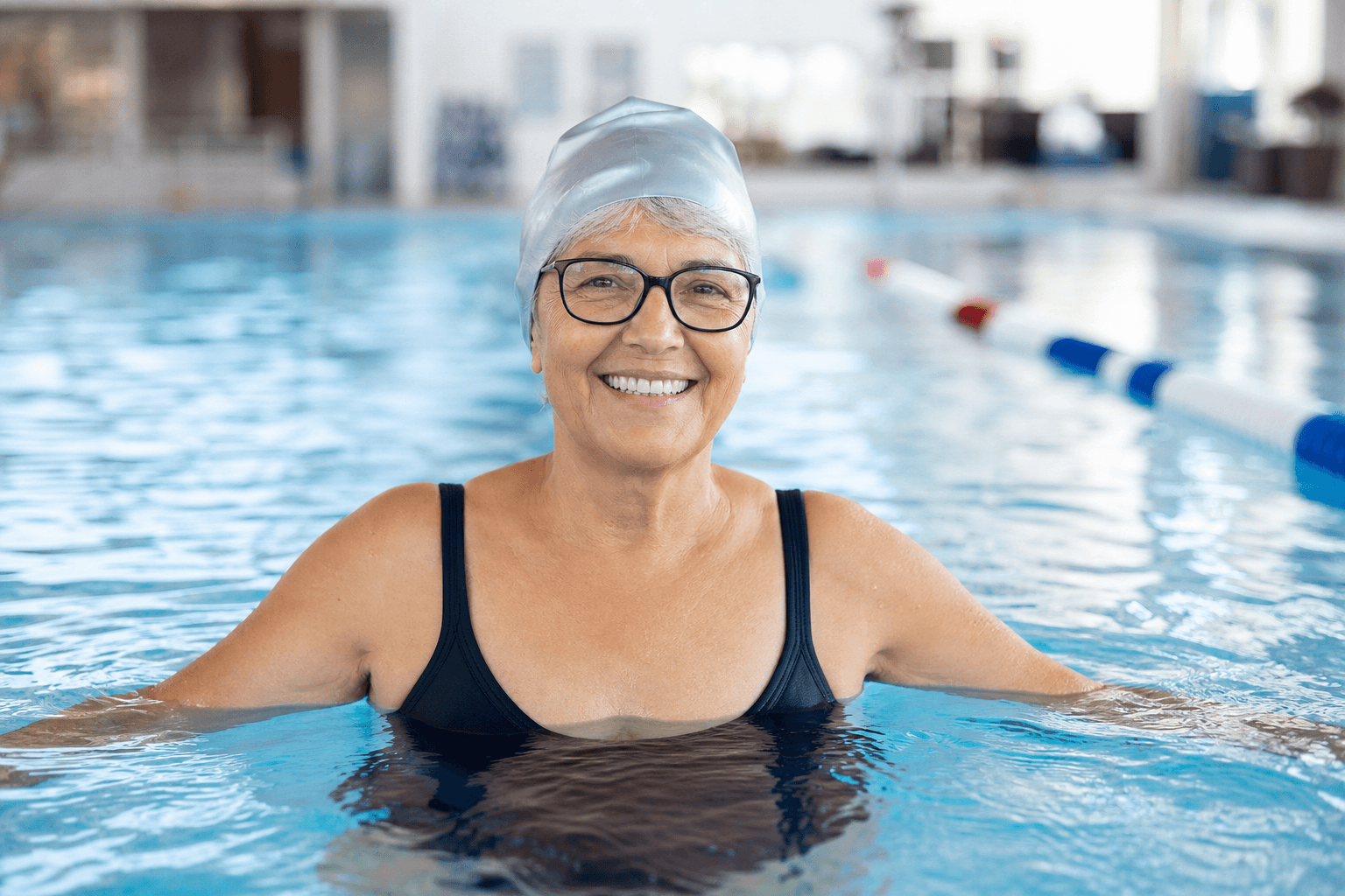 Smiling senior woman swimming in a pool with confidence